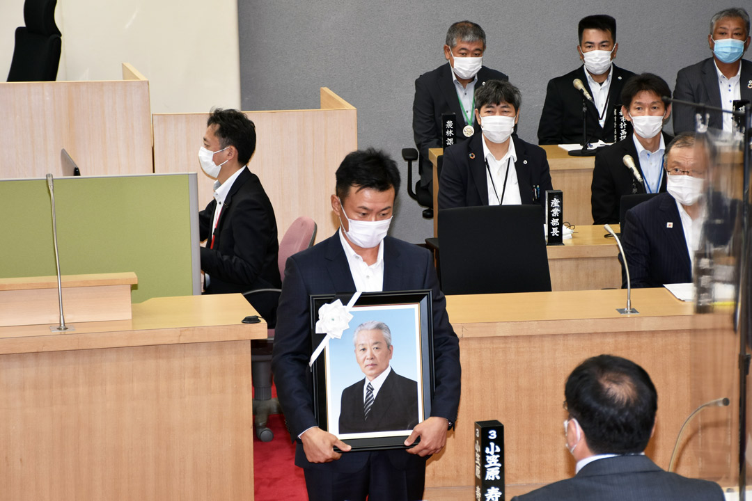  遺影とともにあいさつする松橋さん