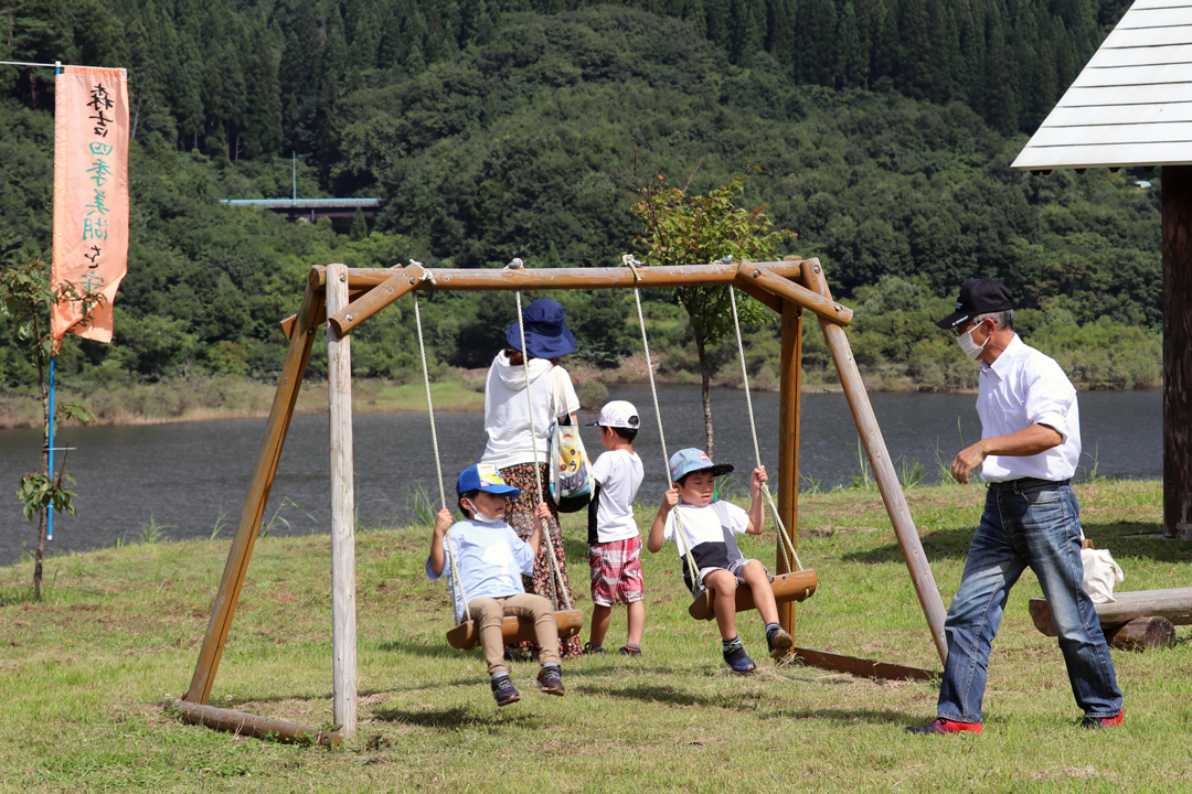 湖畔公園でブランコを楽しむ子どもたち