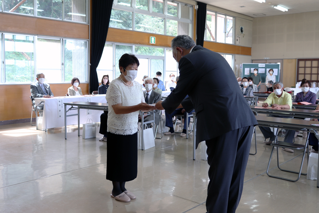 新敬老を代表して祝品を受け取る長岐さん